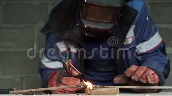 特写焊工焊接两个金属件工人在室内工作动作缓慢视频的预览图