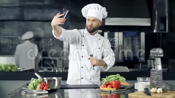 厨师在厨房拍照厨师用刀在手机上自拍视频的预览图