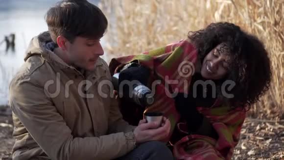 一对夫妇在冰湖边喝热茶放松视频的预览图