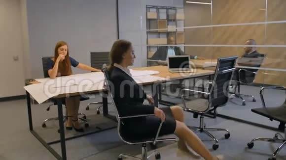 在旋转扶手椅中享受工作时间休息的女孩视频的预览图