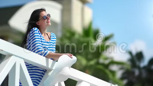 微笑时尚女性在豪华酒店度假村阳台放松享受暑假视频的预览图