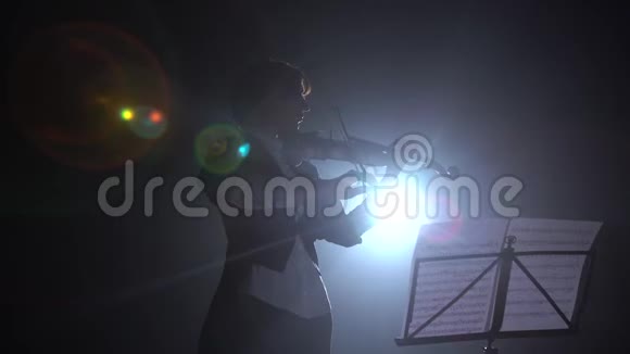 小提琴手拿着灯笼在舞台上表演剪影黑烟背景视频的预览图