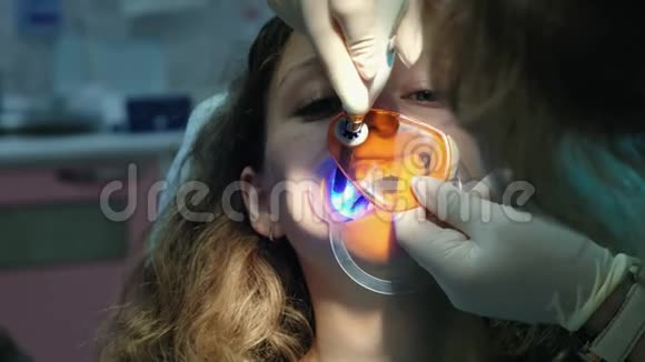 牙医助手用聚合紫外线灯照射病人牙齿拜访口腔医生视频的预览图