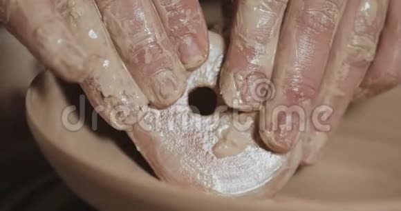 波特在陶工的车轮使用他的手和陶器工具制作陶瓷产品快关门手工制作工艺白色视频的预览图