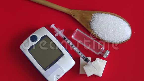 带糖的勺子带胰岛素的胰岛素注射器和红色背景上的血糖仪视频的预览图