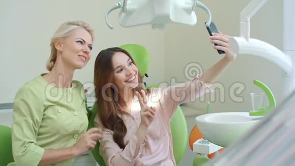 快乐牙医和病人自拍和显示v签名微笑医生视频的预览图