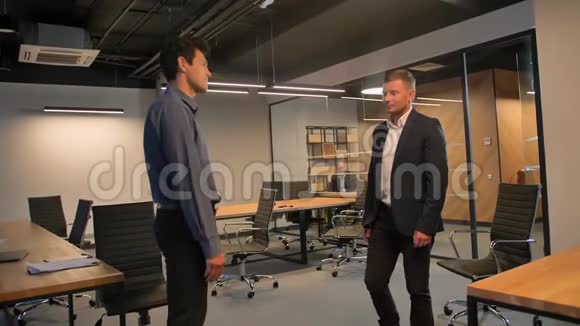 两个商人在办公室里互相握手视频的预览图