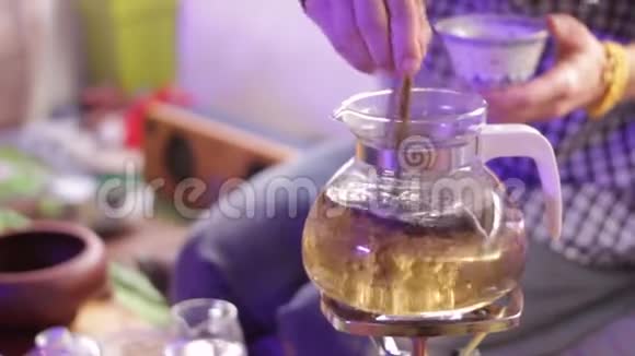 玻璃茶壶里的茶做成的壮观的龙卷风茶叶酿酒视频的预览图