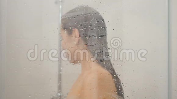 女人把水倒在淋浴房的墙上视频的预览图