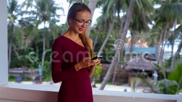 戴眼镜的微笑女人在电话里发短信和谈话视频的预览图