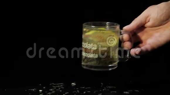 男人手里放了一杯绿茶玻璃杯有机干绿茶叶和柠檬片漂浮在水中视频的预览图