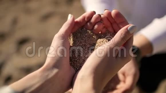 女孩把沙子倒进男人手里视频的预览图