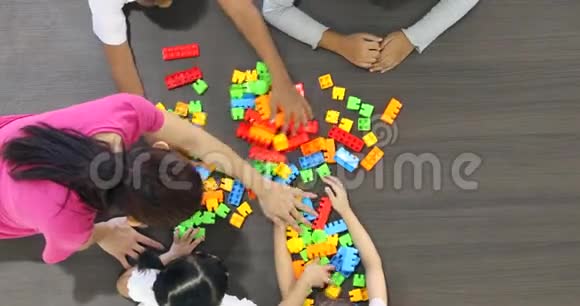 亚洲教师与亚洲学生一起玩彩色积木玩具的平躺场景视频视频的预览图