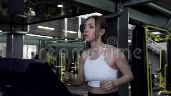 年轻漂亮的女运动员在跑步机上行走结束了一场运动视频的预览图