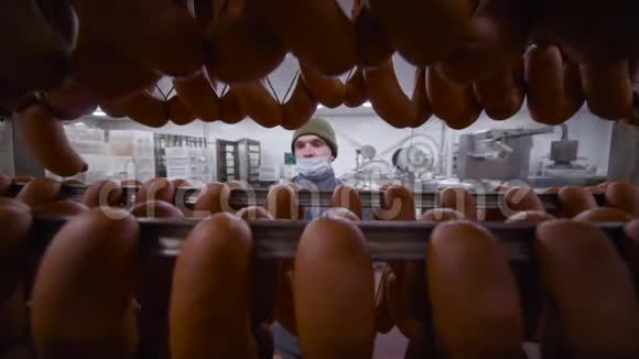 肉制品厂的一名员工端着一大堆香肠视频的预览图