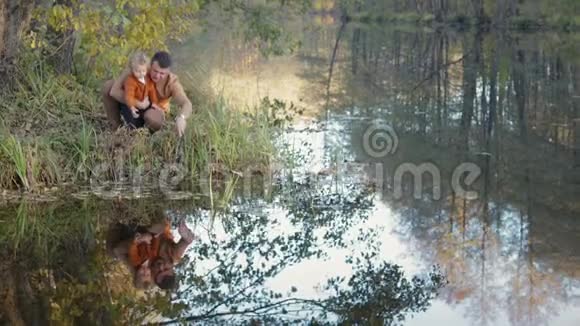一家人坐在湖边倒映在水中视频的预览图