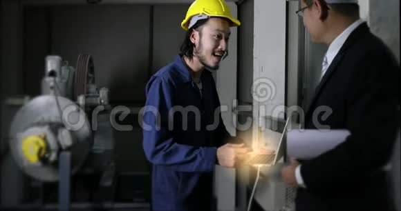年轻的亚洲工程师用笔记本向工厂的高级执行工程师介绍他的工作视频的预览图