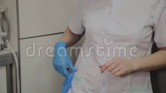 自信的专业女医生戴着口罩和帽子在医院房间戴上蓝色的医疗手套女医生视频的预览图