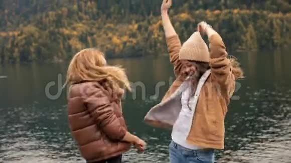 失败的两个女孩在湖上的背景下山舞为一个博客和笑声社交媒体旅游视频的预览图
