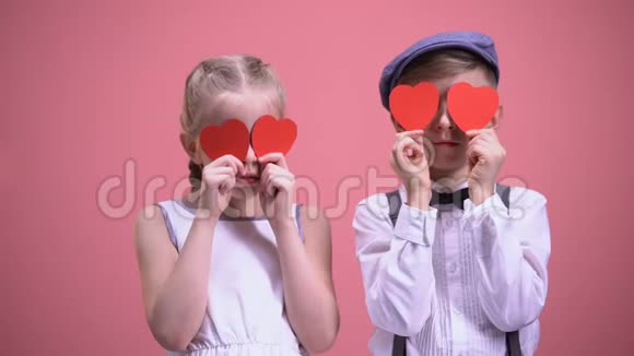 两个孩子用纸心闭上眼睛享受快乐的情人节视频的预览图