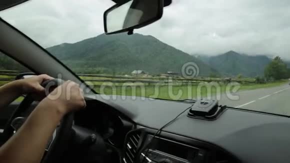 从挡风玻璃看到高地仪表板和方向盘与司机手晨雾上视频的预览图