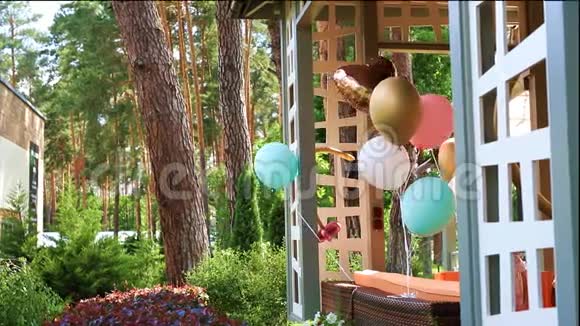一束五颜六色的氦气气球在风上玩耍绑在木制户外露台上作为装饰视频的预览图