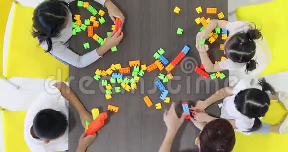 亚洲老师和亚洲学生一起玩彩色积木玩具的平面布景视频视频的预览图