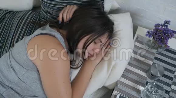 一个怀孕的女孩睡在沙发上醒来喝了一杯水疲惫的孕妇渴望喝一杯视频的预览图