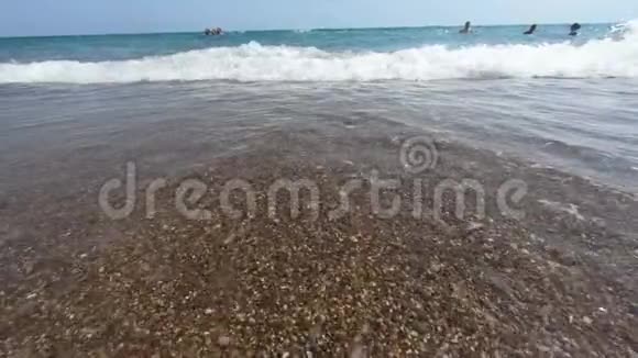 美丽的大海和蓝色的水小浪带着鹅卵石在沙滩上泼水视频的预览图