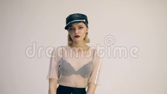 戴着黑色皮帽和红色皮手套的女孩在镜头前摆姿势时尚观念视频的预览图