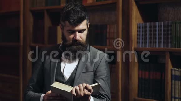 有胡子的人在书架背景上看书在图书馆看书的人大学生读书画像视频的预览图