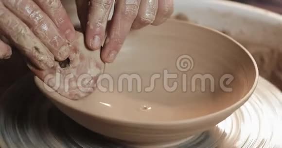 波特在陶工的车轮使用他的手和陶器工具制作陶瓷产品快关门手工制作工艺白色视频的预览图