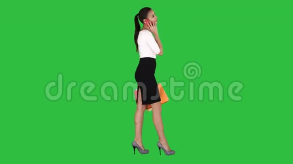 兴奋的女人在手机上说话带着购物袋在绿色屏幕上Chroma键视频的预览图