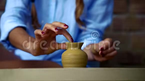 特写陶工展示了妇女在生陶罐上制作的图案视频的预览图