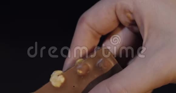 女人手中的黑巧克力块特写视频的预览图