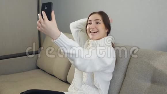 穿毛衣的酷女用手机拍照视频的预览图