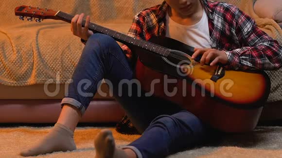 青少年在家弹吉他为学校表演写歌视频的预览图