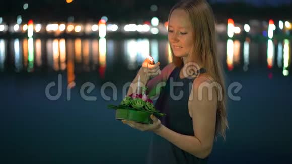 一位美丽的年轻女子慢镜头她点燃了一支蜡烛手里拿着一根克拉特龙庆祝一只卢伊视频的预览图
