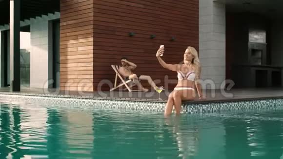 富人夫妇在豪华住宅的游泳池附近放松性感女人拍自拍照片视频的预览图