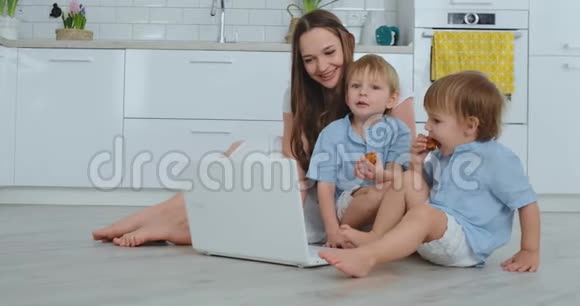 一位有两个孩子的进步的年轻母亲正在通过视频交流与父亲交谈现代技术视频的预览图