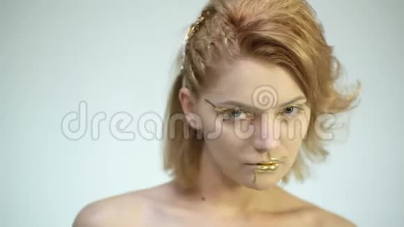 时尚的身体艺术有金色皮肤和嘴唇的女人模特女孩脸肖像魅力闪亮的专业化妆黄金视频的预览图