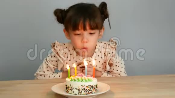 4k可爱的女孩带着微笑的脸和蛋糕在家里和家人一起吹蜡烛庆祝生日视频的预览图