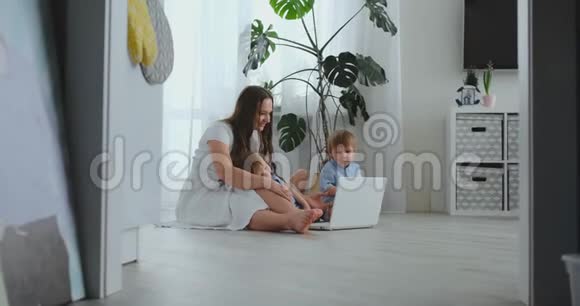 一位有两个孩子的进步的年轻母亲正在通过视频交流与父亲交谈现代技术视频的预览图