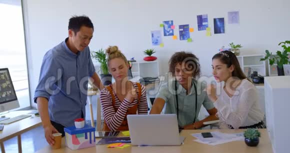 年轻的混血商业人士在办公室里用笔记本电脑工作互相交流视频的预览图