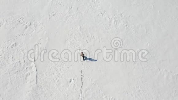 孤独的人在白雪皑皑的北极沙漠中行走从上面看孤独和克服视频的预览图