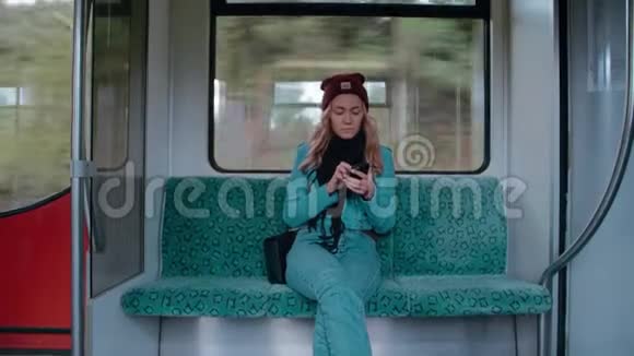 年轻的白种人女孩乘坐地铁或电车使用电话打印信息慢动作视频的预览图