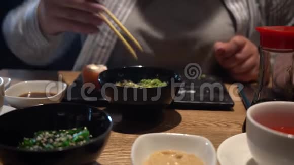 女人用木筷子吃海藻沙拉特写镜头中国筷子吃海藻沙拉视频的预览图