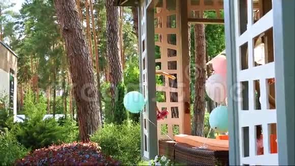 一束五颜六色的氦气气球在风上玩耍绑在木制户外露台上作为装饰视频的预览图