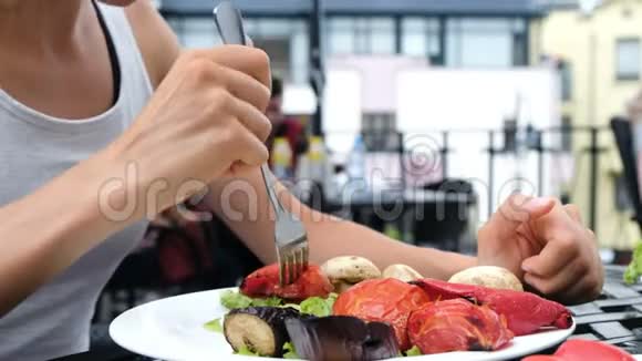 女游客吃烤蔬菜与叉子与新鲜沙拉特写视频的预览图
