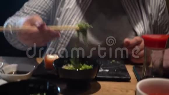 女人用木筷子吃海藻沙拉特写镜头中国筷子吃海藻沙拉视频的预览图